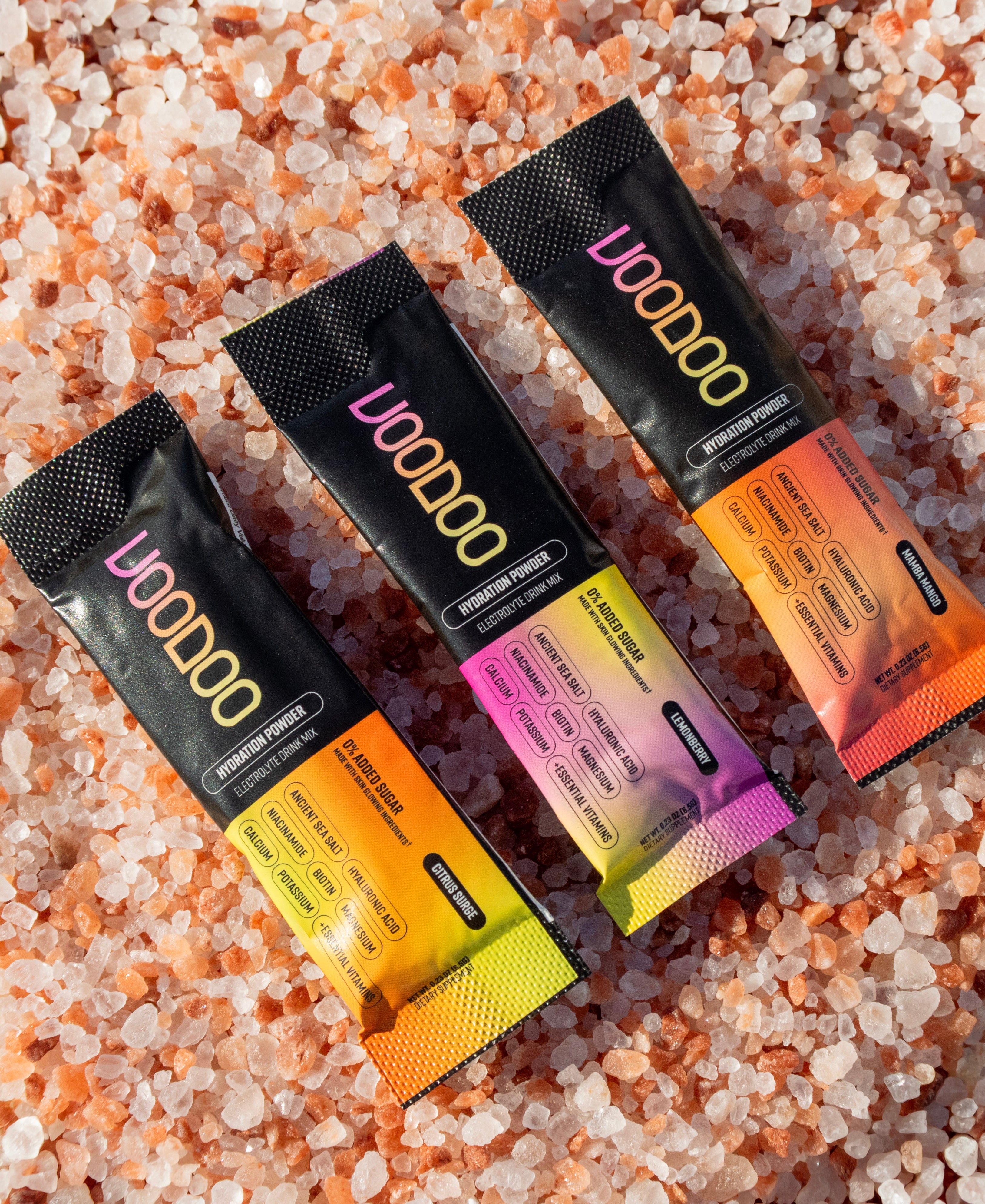 Three VooDoo protein powder packets on pink Himalayan salt